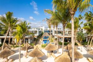 a resort with palm trees and straw umbrellas at TOA Hotel & Spa Zanzibar in Pongwe