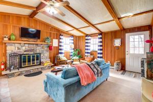 a living room with a blue couch and a stone fireplace at Pet-Friendly Home with Deck at Big Bass Lake! in Gouldsboro