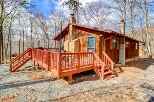 a small house with a large deck in the woods at Pet-Friendly Home with Deck at Big Bass Lake! in Gouldsboro