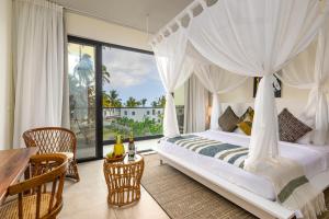 蓬圭TOA Hotel & Spa Zanzibar的一间带床和大窗户的卧室