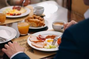 a table with a plate of breakfast food on it at Charles Bridge Palace in Prague