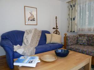 a living room with a blue couch and a table at Ferienwohnung am Wald in Schuttertal