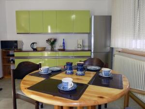 a kitchen with a wooden table with cups and plates on it at Ferienwohnung am Wald in Schuttertal