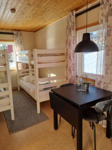 a dining room with two bunk beds and a table at Måvikens Camping in Måviken