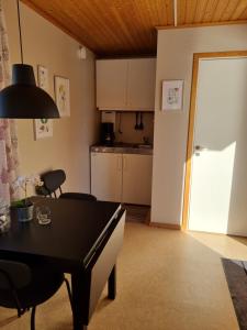 een woonkamer met een tafel en een keuken bij Måvikens Camping in Måviken