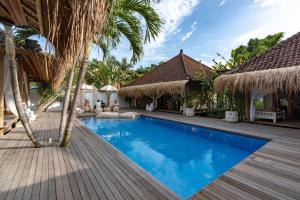 una piscina en un complejo con palmeras en Castaway, en Nusa Lembongan