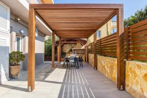 a timber pergola on a patio with a table at Georgia' s Apartment No1 in Maleme