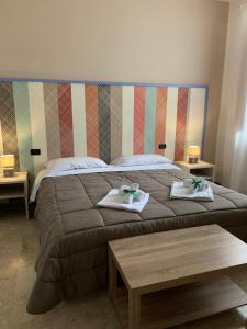 a bedroom with a large bed with two towels at Villa Anna GuestHouse in Brindisi