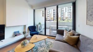 een woonkamer met een bank en een tafel bij Luxe Living in Melbourne