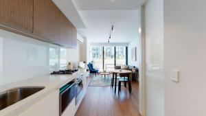 een keuken met een wastafel en een tafel. bij Luxe Living in Melbourne