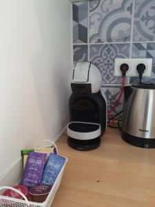 a coffee maker sitting on top of a wooden floor at Appartement Pérols Centre in Pérols