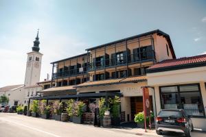 a building with a clock tower on a street at Hotel Hvala Superior - Topli Val in Kobarid +35 photos