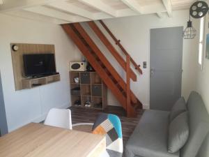 - un salon avec une table à manger et un escalier dans l'établissement Maison à 300 m de la plage., à La Cotinière