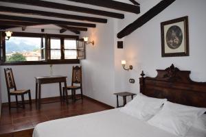 a bedroom with a bed and a table and chairs at Habitaciones Casona De Linares in Selaya
