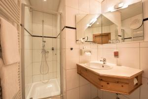 a bathroom with a shower and a sink and a mirror at AKZENT Hotel Krone in Helmstadt