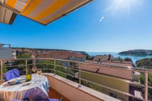a balcony with a table and a view of the water at Villa Alexandra 3 in Pješčana Uvala 