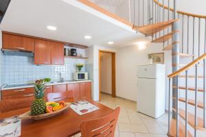 a kitchen with a table with a bowl of fruit at Villa Alexandra 3 in Pješčana Uvala 