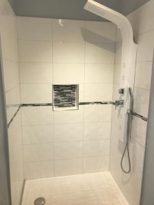 a bathroom with a shower with white tiles at Les embruns in Saint-Jean-de-Monts