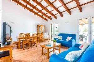 uma sala de estar com um sofá azul e uma mesa em Villa Flomertor 2 em Cala en Blanes