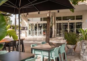 een openluchtcafé met tafels en stoelen en een parasol bij Hotel SB Express Tarragona in Tarragona