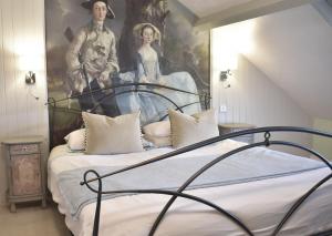 a bedroom with a portrait of a man and a woman at Davenford Cotswold Gardens in Stow on the Wold