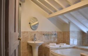a bathroom with a sink and a tub and a mirror at Davenford Cotswold Gardens in Stow on the Wold