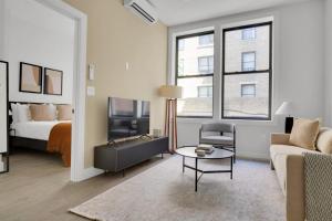 een woonkamer met een bed, een bank en een tafel bij UWS 1BR w Elevator WD nr Central Park NYC-857 in New York