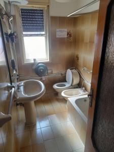 a bathroom with two toilets and a sink and a window at Bed and fly Aeroporto Catania reception h24 in Catania