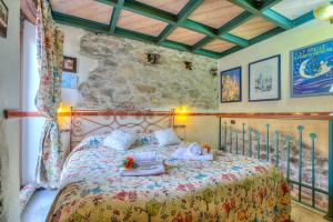 a bedroom with a large bed with a stone wall at Apartments In The Heart of Medieval Village - Happy Rentals in Apricale