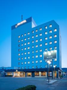 a hotel building with a sign in front of it at EN HOTEL Ise in Ise