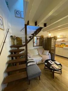 salon ze spiralnymi schodami i kanapą w obiekcie Duplex Atelier / coeur de Lourmarin w mieście Lourmarin