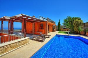 a villa with a swimming pool and a house at Villa Rodanthi by PosarelliVillas in Kástellos