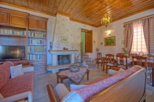 a living room with a fireplace and a dining room at Villa Rodanthi by PosarelliVillas in Kástellos