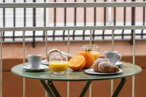 una mesa con una bandeja de naranjas y tazas de zumo de naranja en ANNA'S DREAM BED & BREAKFAST, en Avola