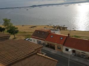 an aerial view of roofs of buildings and a body of water at Boa Vista Playa As Sinas en Vilanova de Arousa in Villanueva de Arosa