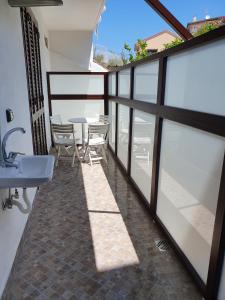 een balkon met een wastafel en een tafel met stoelen bij La Casetta in Palinuro