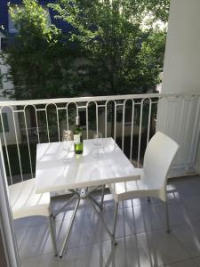 uma mesa branca e 2 cadeiras numa varanda em Appartement cozy pour curistes et touristes em Salies-de-Béarn