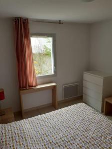 um quarto com uma cama e uma janela em Appartement cozy pour curistes et touristes em Salies-de-Béarn