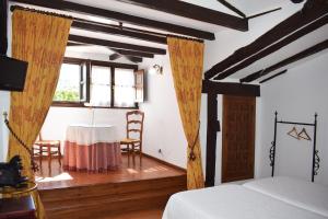 a bedroom with a table and a bed and a window at Habitaciones Casona De Linares in Selaya