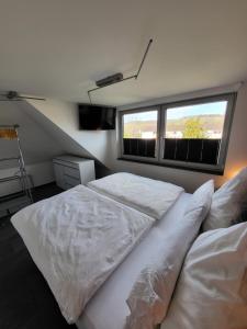 1 Schlafzimmer mit 2 weißen Betten und einem Fenster in der Unterkunft Exklusive Wohnung mit Ahrblick 1 und Dachterrasse in Bad Neuenahr-Ahrweiler