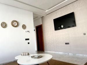 a white room with a table and a tv on the wall at Cosy central home near the beach in Agadir