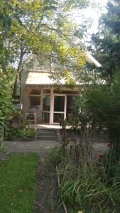 ein kleines Haus mit einer Veranda im Hof in der Unterkunft SUBASA GREEN GARDEN in Szeged