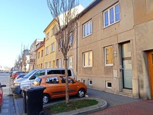a small orange car parked next to a building at Štolcova room in Komárov