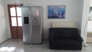 einen silbernen Kühlschrank in einem Zimmer mit Stuhl in der Unterkunft SUBASA GREEN GARDEN in Szeged