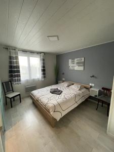 a bedroom with a large bed and a chair at Le Glandasse in Die