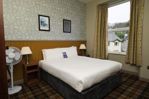 um quarto de hotel com uma cama e uma janela em Oakbank at The Angel Inn em Bowness-on-Windermere