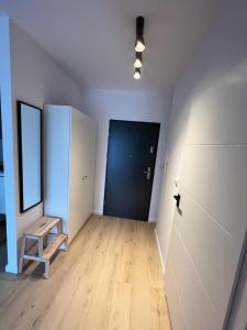an empty room with a blue door and a bench at Apartamenty Akademicka przy Onkologii 2 in Bydgoszcz