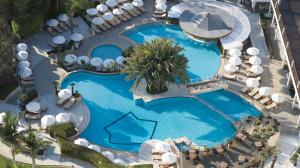 een uitzicht over het zwembad van een resort bij Mediterranean Beach Hotel in Limassol