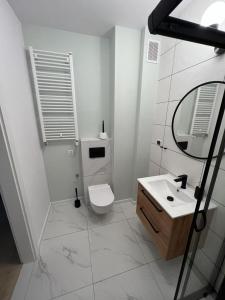 Baño blanco con aseo y lavamanos en Apartamenty Akademicka przy Onkologii 2, en Bydgoszcz