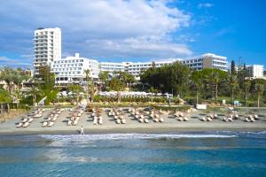 una spiaggia con un mucchio di sedie a sdraio e palazzi di Mediterranean Beach Hotel a Limassol